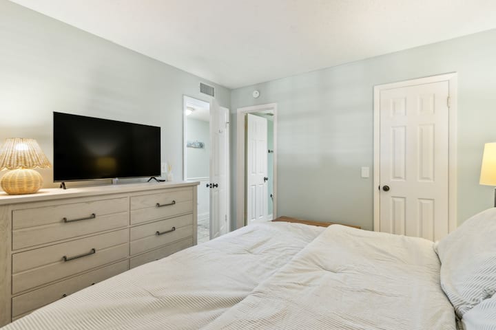 El dormitorio de invitados tiene vestidor, TV y acceso al baño compartido del pasillo.