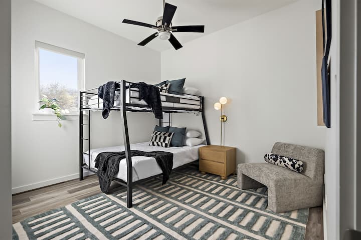 Удобна и стилска соба на спрат со модерен кревет на спрат, мека постелнина и удобна фотелја.