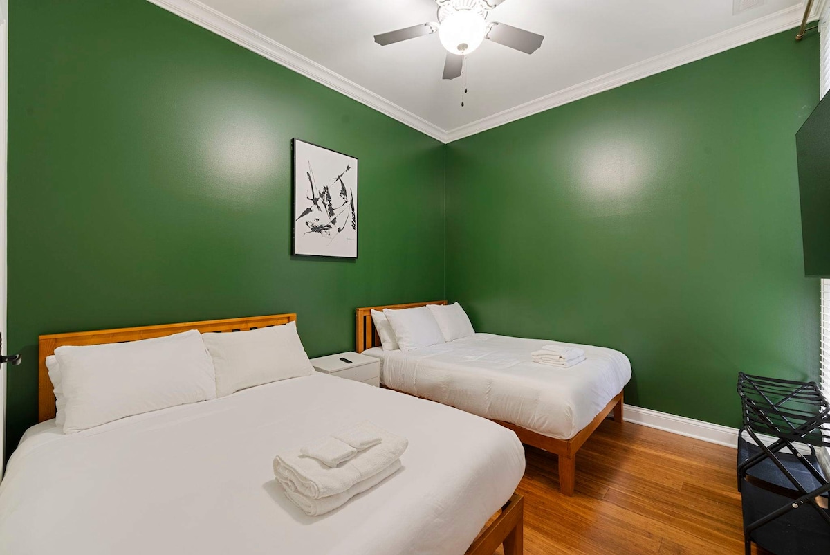 تحتوي غرفة النوم المريحة هذه على سريرين مزدوجين مريحين ولوحة تلفزيونية مثبتة