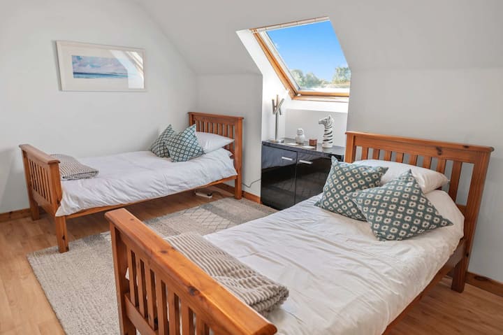 Dormitorio doble con dos camas individuales con ropa de cama cómoda.