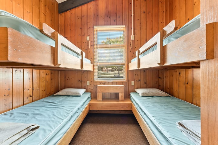 Habitación con literas con cuatro camas individuales, perfecta para estadías infantiles o grupales, que ofrece una experiencia cómoda y divertida en la cabaña.