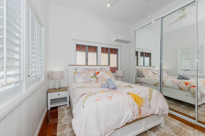 Dormitorio principal con cama tamaño queen, almacenamiento incorporado y aire acondicionado.