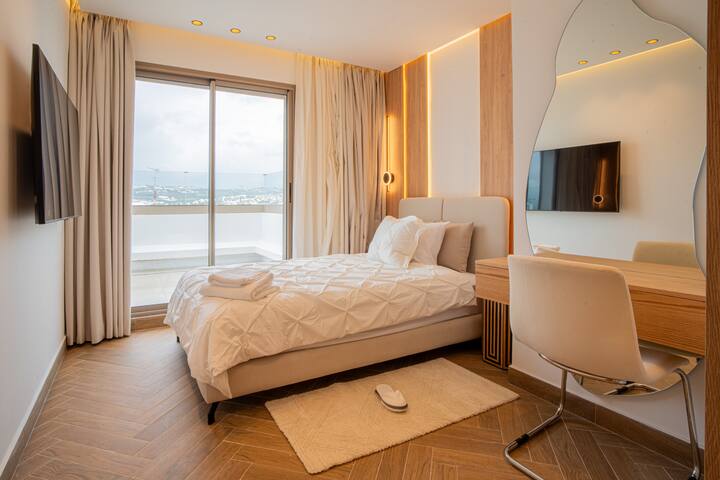 Quarto 3 com colchão de tamanho completo, smart TV e espaço de trabalho com cadeira e acesso ao terraço