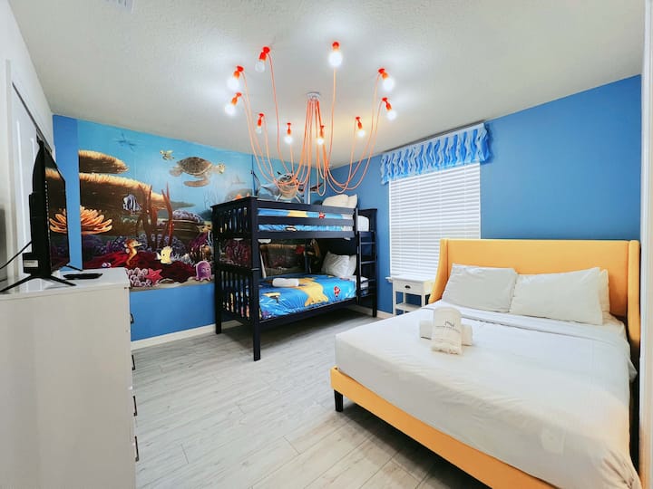 Moderná útulná spálňa s výraznými oranžovými akcentmi, plyšovou posteľnou bielizňou a štýlovým osvetlením
