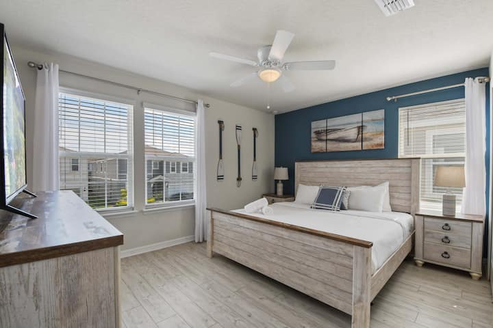 Spálňa s pobrežnou tematikou s rustikálnou drevenou výzdobou, prirodzeným svetlom a pokojnou atmosférou.