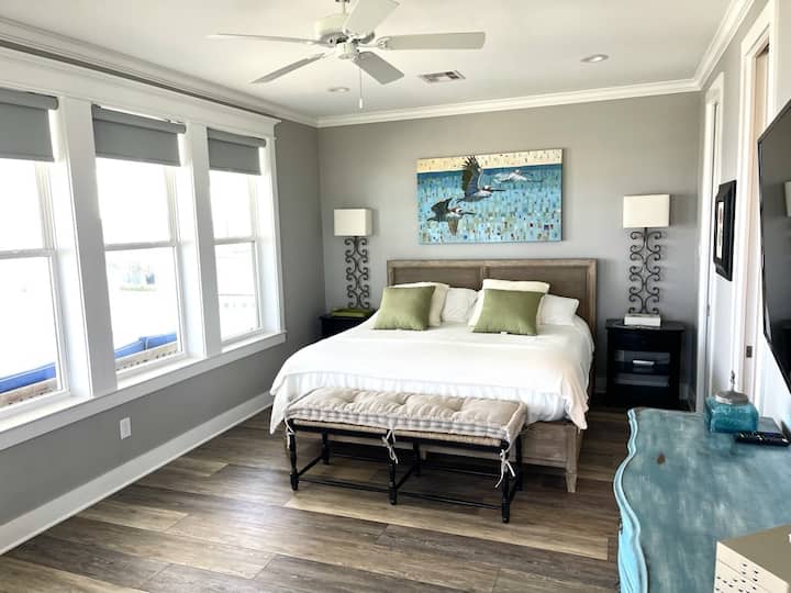 غرفة نوم رئيسية مع منطقة جلوس وسرير بمقاس كبير