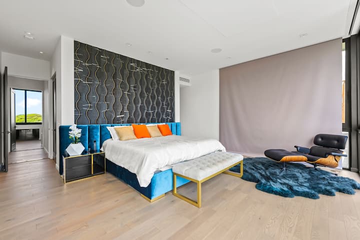 Bu qəşəng qonaq otağında dizayner divar prosedurları, laylı tekstil və ada havasına açılan səxavətli şüşə qapılar var.