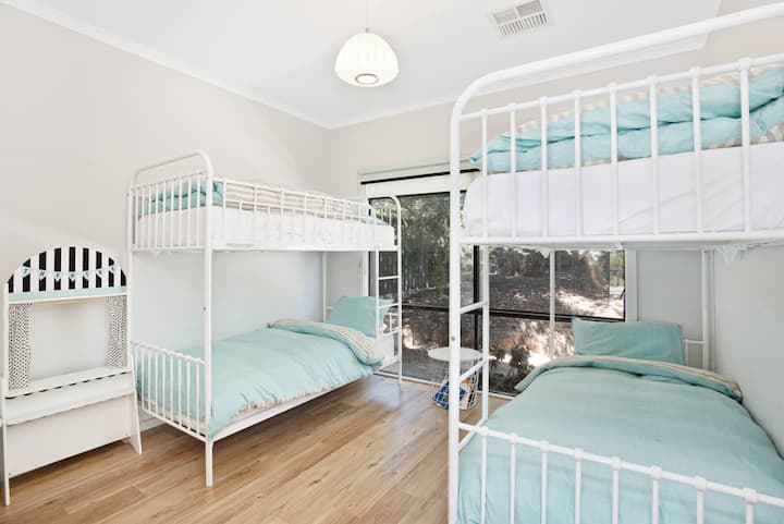 Spavaća soba opremljena s dva kompleta kreveta na kat, idealna za grupne boravke ili djecu.