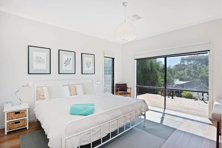 Glavna spavaća soba svijetlog uređenja s uokvirenim umjetničkim djelima.