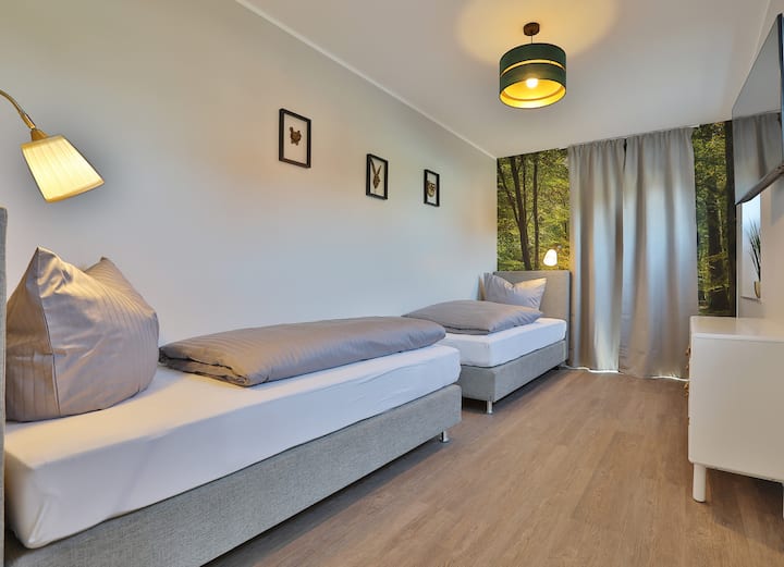 غرفة نوم بسريرين مرتبين بقاعدة زنبركية