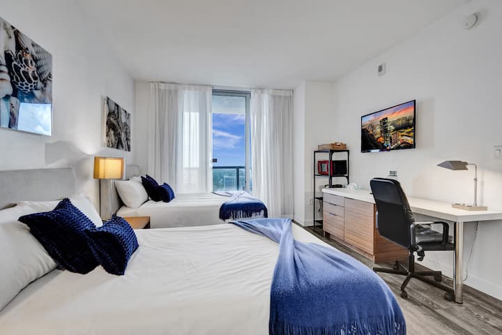 Camera accogliente con 2 letti matrimoniali e vista sulla città