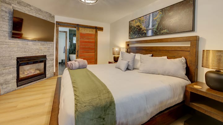 Dormitorio principal en la planta principal con acogedora chimenea y TV inteligente