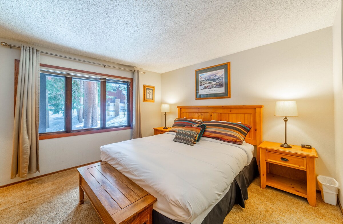 ห้องนอนหลักมีเตียงขนาดคิงไซส์และหน้าต่างมองเห็นป่าต้นสน