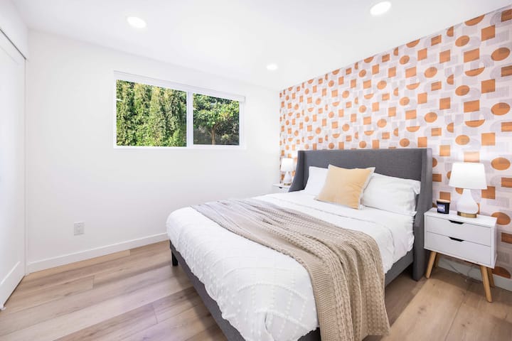  U ovoj svijetloj i modernoj spavaćoj sobi čeka vas udoban krevet s mekanom posteljinom i udobnim bež tekstom. Jedinstveni naglasak na tapetama daje karakter, dok veliki prozor ispunjava prostor prirodnim svjetlom i bujnim zelenilom.