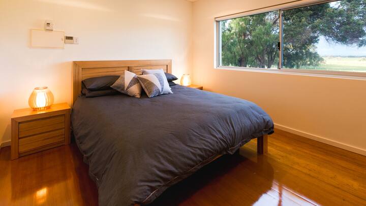 Ova spavaća soba s bračnim krevetom nalazi se na katu i uređena je u prirodnim tonovima. Iz nje se pruža pogled na krošnje drveća, a u njoj ćete se moći opustiti nakon dugih dana istraživanja.