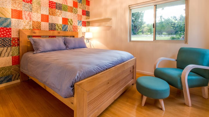 Ova spavaća soba s bračnim krevetom i živopisnim zidom s motivom na kojem se vidi vrt ujedno je zabavna i udobna, a ujedno i šarmantno utočište za opuštanje.