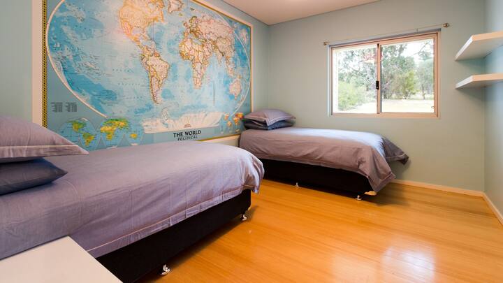 Ostavite mladu maštu da luta u ovoj dvokrevetnoj sobi s temom putovanja, gdje se pogled na drveće kroz prozor nadopunjuje blagim tonovima i inspirativnim muralom.