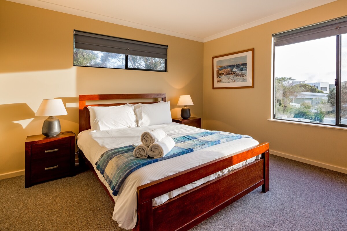 ห้องนอนควีนไซส์ชั้นบนห้องที่สองให้ความเป็นส่วนตัวและการนอนหลับอย่างสงบพร้อมวิวพุ่มไม้