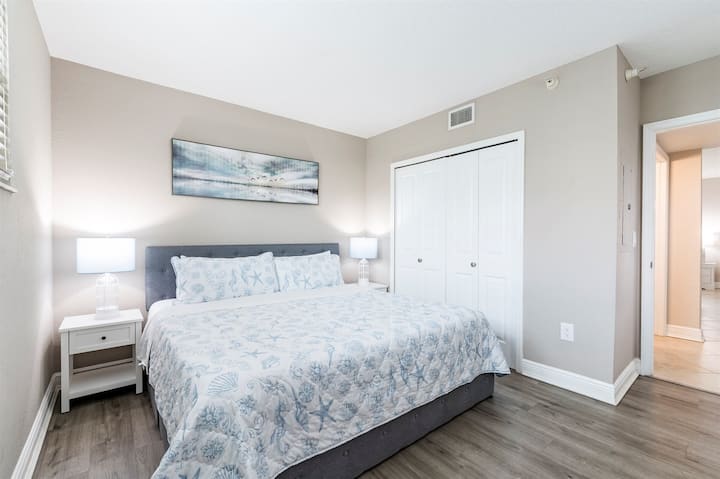 Deuxième chambre spacieuse avec un très grand lit et accès à un balcon privé.