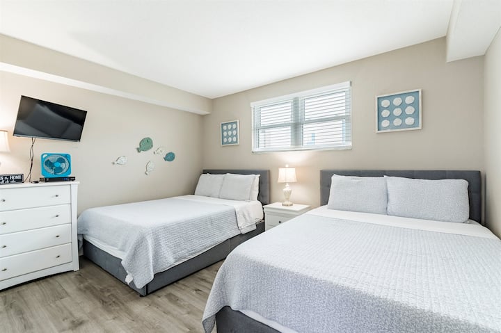 Chambre confortable avec deux lits queen size.