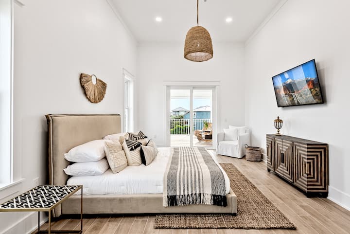 ห้องนอนที่เงียบสงบและกว้างขวางมีเตียงขนาดคิงไซส์ที่อบอุ่นพื้นผิวธรรมชาติและโทนสีเอิร์ธโทนที่นุ่มนวล