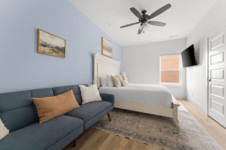 - Oddýchnite si v tejto spálni s plyšovou manželskou posteľou King, ktorá je ideálna na pokojné noci a lenivé rána.
- Sledujte svoj obľúbený seriál z pohodlia postele alebo sa ponorte do námorníckej pohovky.
- Mäkká modrá akcentová stena a zemité tóny pripravujú pôdu pre upokojujúci a útulný únik.