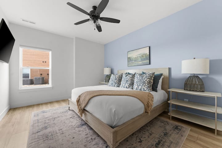 - Oddýchnite si v útulnej manželskej posteli zarámovanej mäkkou modrou zvýraznenou stenou a vrstvenými vankúšmi.
- Teplé drevené tóny, neutrálny koberec a upokojujúca potlač krajiny vytvárajú pokojnú atmosféru.
- Nástenná televízia, osvetlenie nočného stolíka a zatemňovacie rolety ponúkajú pohodlie vo dne aj v noci.