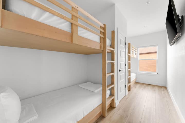 - Zabudované drevené poschodové postele ponúkajú útulné a hravé prostredie pre deti alebo ďalších hostí.
- Vybavená ostrou bielou posteľnou bielizňou, jasnými svetlami a televízorom namontovaným na filmové večery.
- Veselé útočisko, ktoré spája pohodlie, funkčnosť a náznak rustikálneho šarmu zrubu