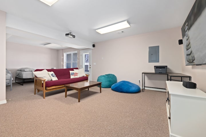 تحتوي غرفة نومنا الرابعة في الطابق السفلي على سرير بحجم كوين وسرير كامل/مزدوج وأريكة سرير وتلفزيون ذكي كبير وكراسي بين باج.