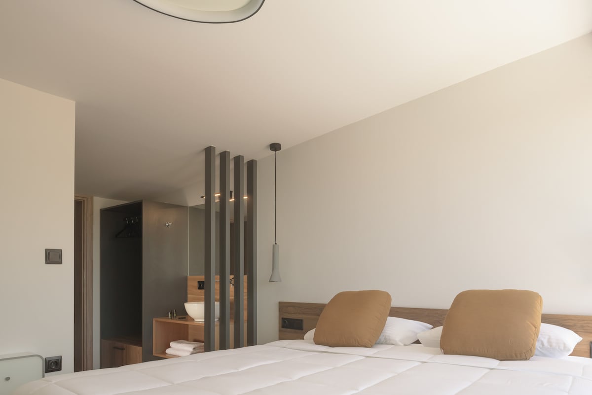 Dvokrevetna soba u potkrovlju minimalističkog dizajna.