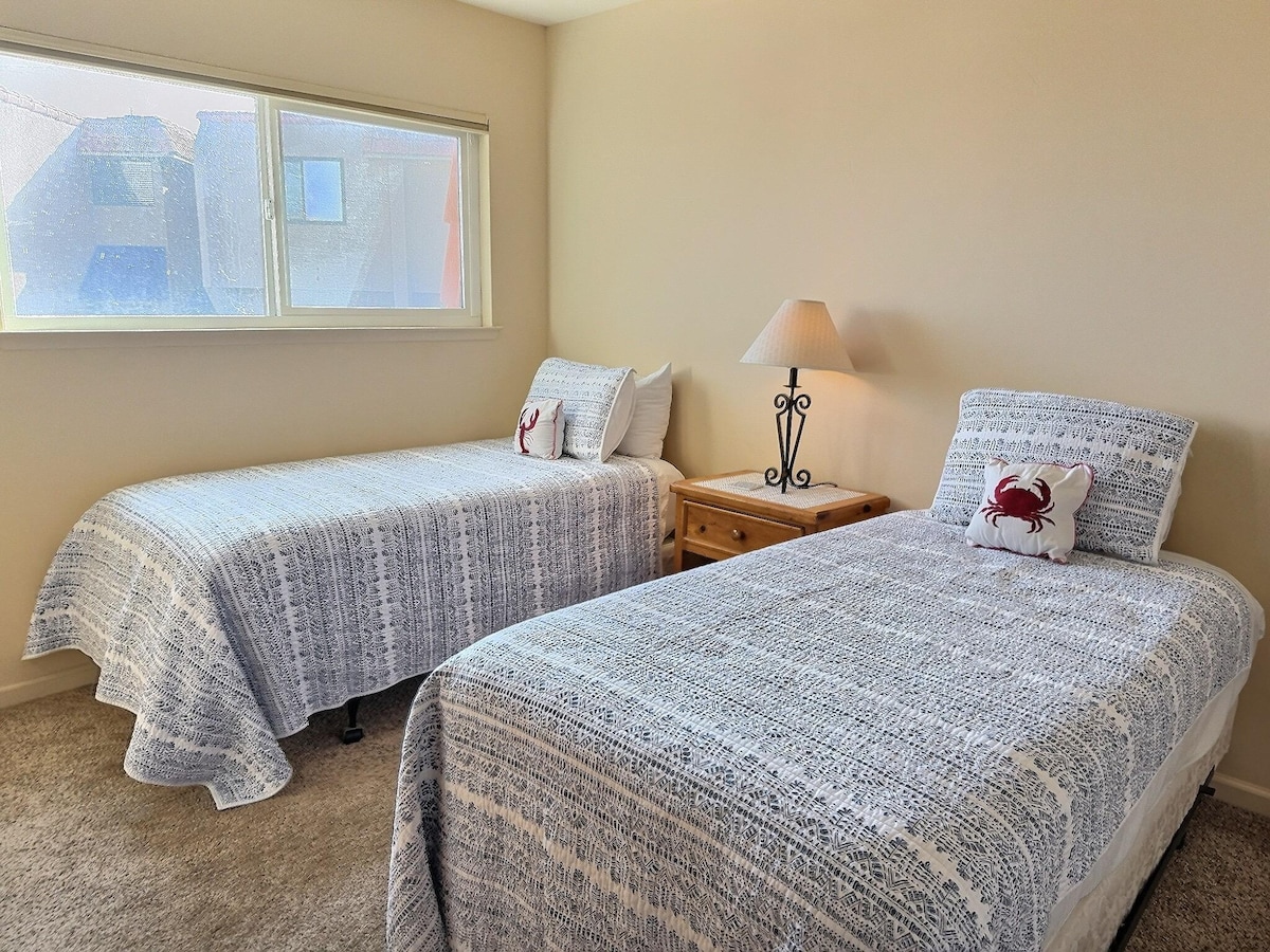 El segundo dormitorio cuenta con dos camas individuales, un vestidor y un televisor.