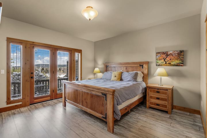 Голямо двойно легло в основен апартамент с достъп до палубата, изглед към планината