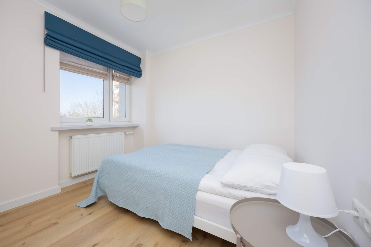 一间时尚的卧室，配有一张双人床和一扇大窗户。