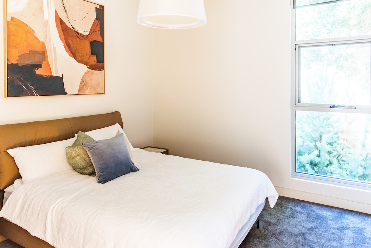 Priestranná spálňa s mäkkým matracom a vankúšmi.