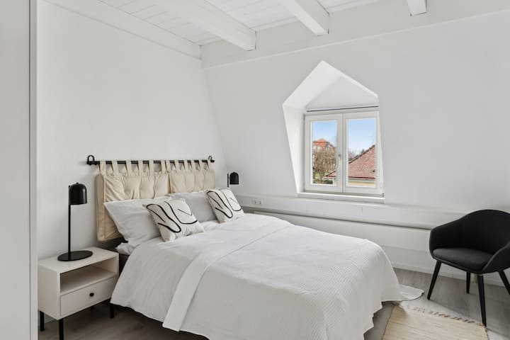 Спална соба 5 – поглед кон запад со поглед кон замокот 
Пространа соба со двоен кревет од 1,40м, гардероба и огледало – со уникатен поглед на замокот Тетнанг.