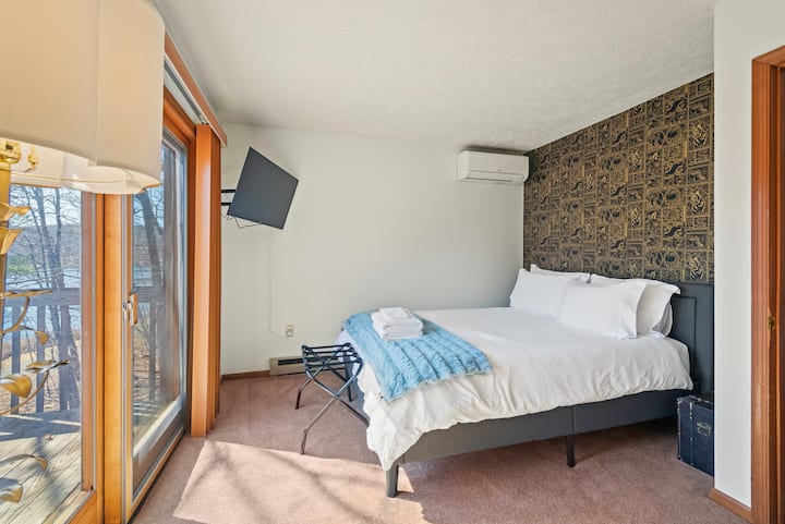 Primary bedroom features a queen bed with access to the deck.