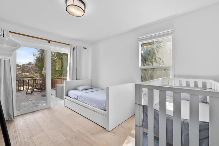 Slaapkamer met uitschuifbed met twee eenpersoonsbedden en een wiegje