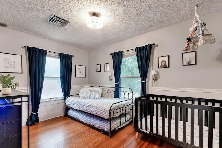 Dormitorio con sofá cama con cama nido (2 camas individuales) y cuna.