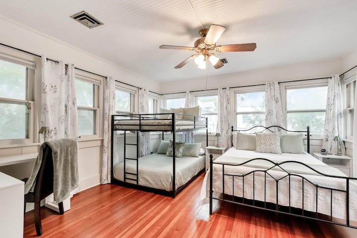 Dormitorio trasero con muchas ventanas, cama tamaño queen y litera completa