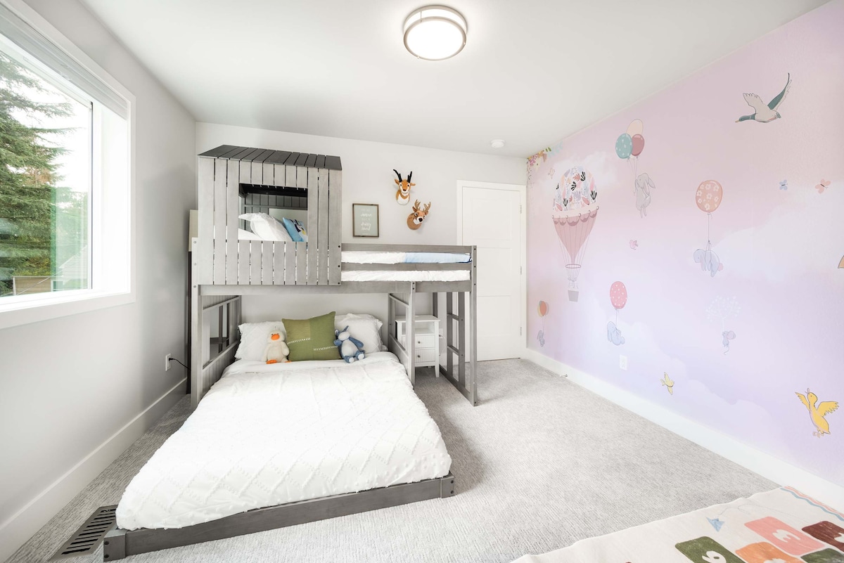 Una lúdica litera, adornada con lindos lujosos animales y un mural inspirado en cuento de hadas, crea una escapada de ensueño para los pequeños aventureros.