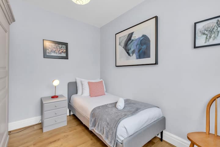 Tercer dormitorio con una cama individual, escritorio y estantería.