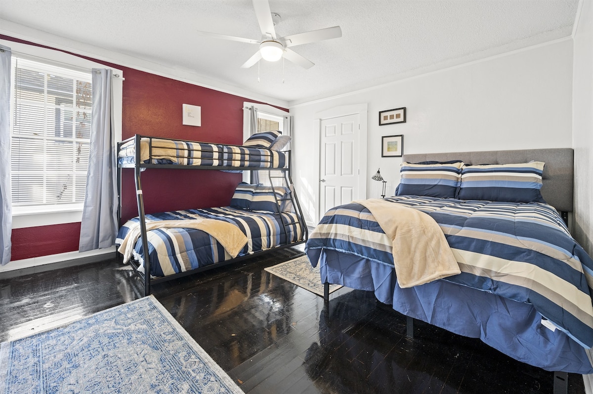 Habitación con literas equipada con dos camas completas, una cama doble y un televisor inteligente para una estancia divertida.