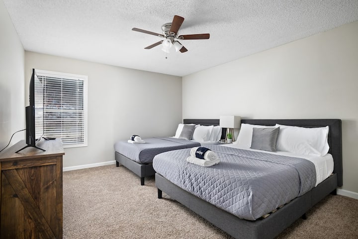 Priestranná spálňa s dvoma manželskými posteľami, ideálna na pokojný nočný odpočinok.