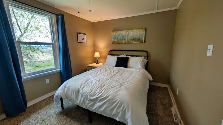 Dormitorio con cama queen