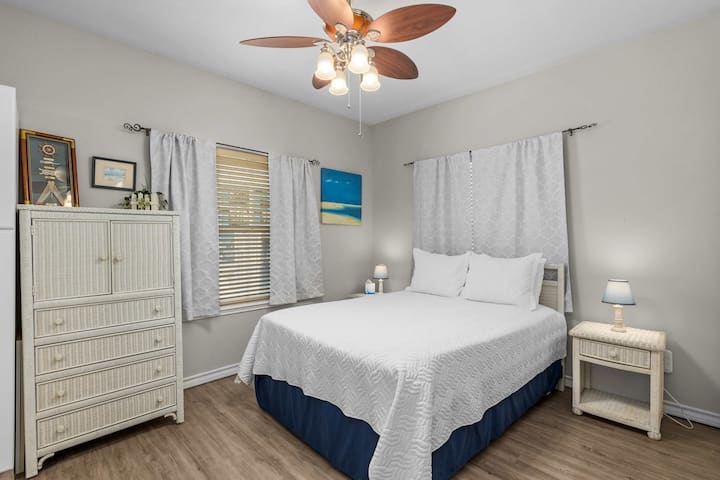 להירגע בחדר השינה הראשי עם מיטת קווין סייז וקסם חופי.