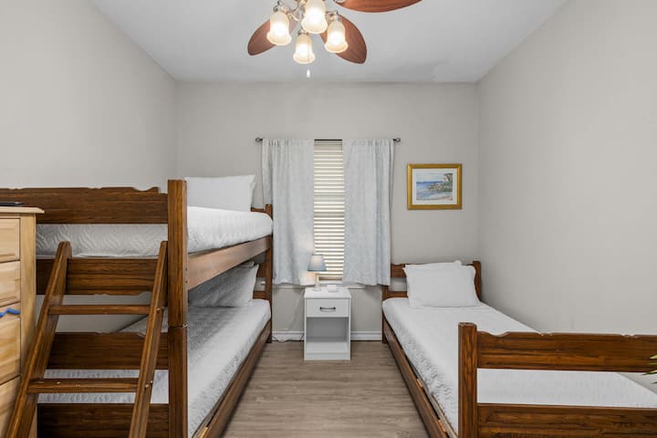 חדר עם מיטות קומותיים עם שלוש מיטות זוגיות, מקום בילוי מועדף לילדים.