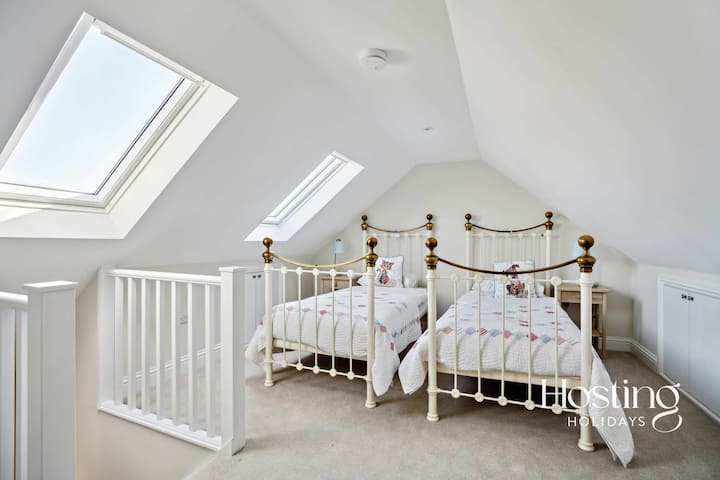 Chambre loft unique avec lits jumeaux sous des puits de lumière.
