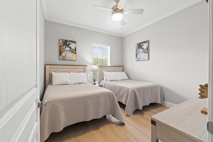Perfeito para crianças ou hóspedes adicionais, este quarto sereno dispõe de duas camas completas de pelúcia, decoração costeira calmante e iluminação natural suave para uma estadia tranquila.
