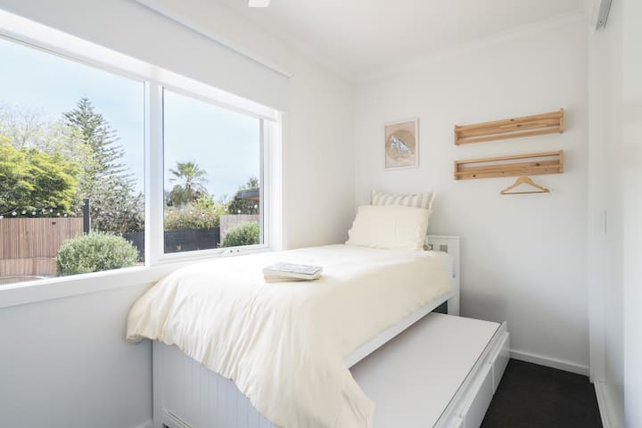 Jednokrevetna spavaća soba s ventilatorom na stropu i krevetom na razvlačenje