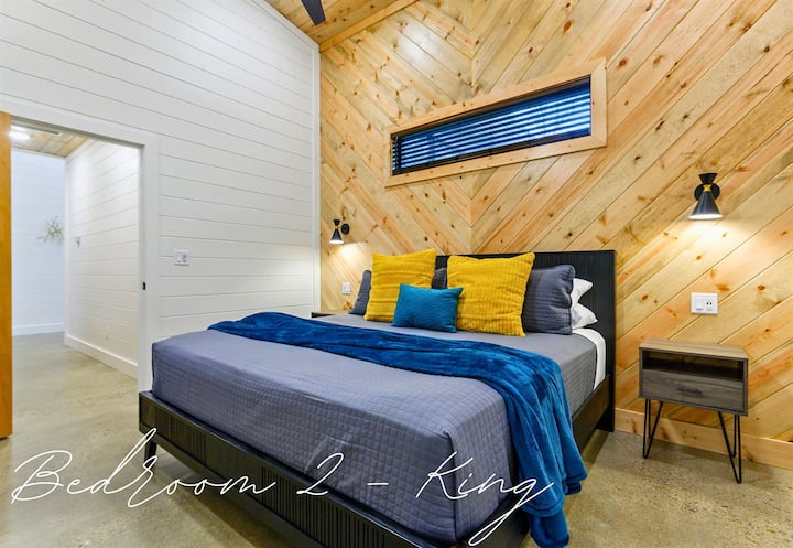 Во спалната соба 2 има и брачен кревет (широк 150-179 см), удобна постелнина и модерни дрвени облоги кои создаваат совршен спој на удобност и стил.